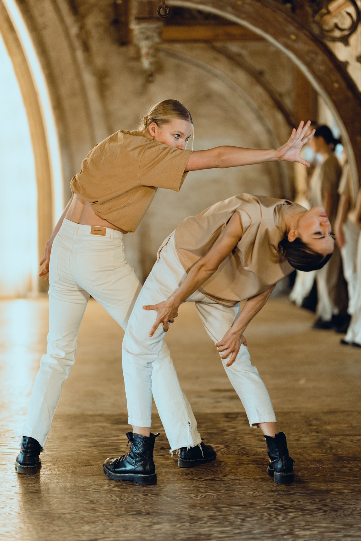 Two dancers in matching outfits performing in a decorative indoor setting.